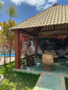 a wooden gazebo with chairs and a table at Pousada Mares do Sul in Conde