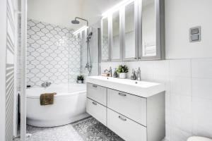 La salle de bains blanche est pourvue d'un lavabo, d'une baignoire et de toilettes. dans l'établissement A5 Apáczai Apartment, à Budapest