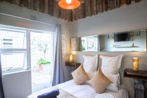 a bedroom with a bed with white pillows and a window at Melite Rooms in Strand