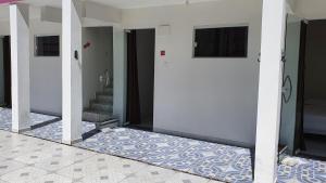 グアイビムにあるPousada Sol Nascenteの白いドア2つとタイルフロアの廊下