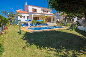 a villa with a swimming pool in front of a house at Casa das Palmeiras by OCvillas in Albufeira