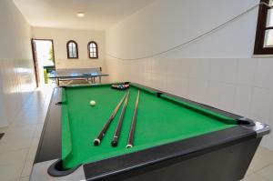 a pool table with cue balls and bats on it at Casa das Palmeiras by OCvillas in Albufeira