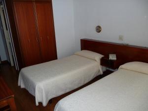 a hotel room with two beds and two lamps at Hostal Liebana in Santander