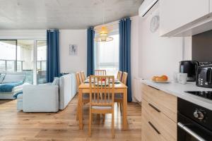 uma cozinha com mesa e cadeiras num quarto em Lux Family Apartment Nadmorskie Tarasy by Renters em Gdynia