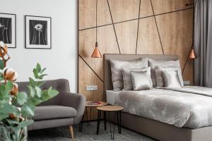 a bedroom with a bed and a chair and a table at Hotel Osvit in Mladá Boleslav