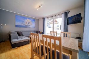 comedor y sala de estar con mesa y sofá en Apartment Riviera 503-1 Lipno Home, en Lipno nad Vltavou