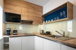 a kitchen with white cabinets and a sink and a microwave at Hotel Osvit in Mladá Boleslav