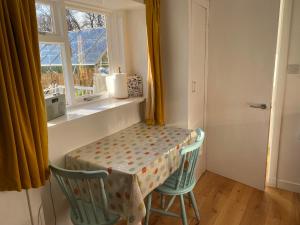 a table and two chairs in a room with a window at The Paddle Nook in Pitlochry