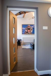um corredor que leva a uma sala de estar com um quadro em Tiger Roof Terrace Lymm em Lymm