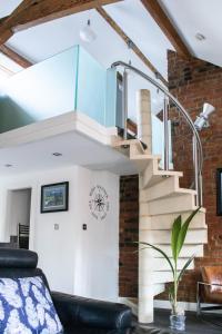 a living room with a spiral staircase in a loft at Tiger Roof Terrace Lymm in Lymm