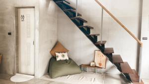 a stairway with a green ottoman under a staircase at Slack BnB in Xiaoliuqiu