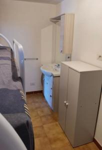 a small room with a bed and a sink at Appartamento Torre 82 in Torre Dei Corsari