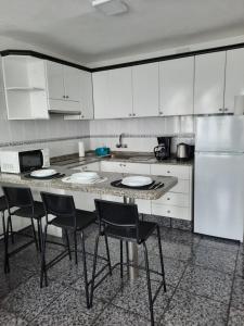a kitchen with a table with chairs and a refrigerator at Playa del Inglés Céntrico Los Molinos 135 in Playa del Ingles