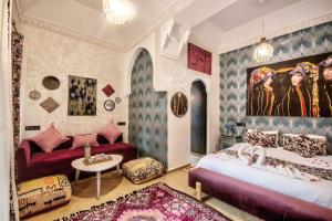 um quarto com 2 camas, um sofá e uma mesa em Riad Les Oliviers & Spa em Marrakech