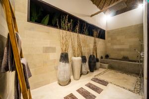 a bathroom with four vases on the wall at Villa Jac in Selong Belanak +18 photos