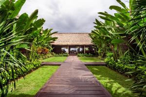 a walkway leading to a building in a garden at Villa Jac in Selong Belanak