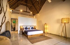 a bedroom with a bed and a lamp in a room at Villa Jac in Selong Belanak