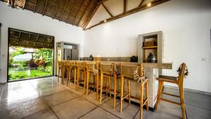 a row of chairs in a kitchen with a bar at Villa Jac in Selong Belanak