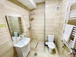 a bathroom with a toilet and a sink and a shower at Summerland Studios Nuba in Mamaia +27 photos