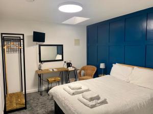 a bedroom with a large bed with two towels on it at The Village Inn in Northallerton