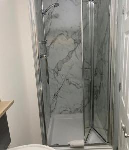 a shower with a glass door in a bathroom at The Village Inn in Northallerton