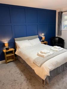 a bedroom with a large bed with blue walls at The Village Inn in Northallerton
