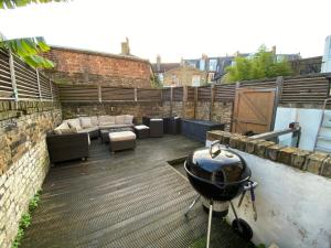 a rooftop patio with a grill on top of it at A sun drenched Garden Flat in the heart of Fulham in London