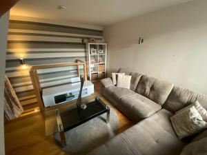ein Wohnzimmer mit einem Sofa und einem TV in der Unterkunft A sun drenched Garden Flat in the heart of Fulham in London