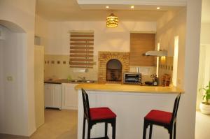 une cuisine avec deux chaises rouges sur un comptoir dans l'établissement VILLA KENZA, à Midoun