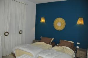 - une chambre avec un lit et un miroir sur un mur bleu dans l'établissement VILLA KENZA, à Midoun