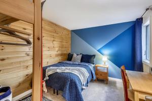 una camera blu con un letto e una parete in legno di Whiffletree F6 a Killington