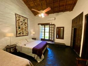 a bedroom with two beds and a ceiling fan at Posada Morotí in Esquina