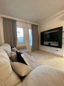 un soggiorno con divano e TV a schermo piatto di OLIVA NOVA GOLF BEACH & RESORT Club Sevilla V a Oliva