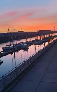 un port de plaisance avec des bateaux dans l'eau au coucher du soleil dans l'établissement Luxuswohnung mit Weserblick nähe City, à Brême