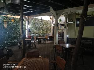a restaurant with tables and chairs and a wall at Casa Lucescu in Vatra Dornei