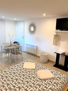 a living room with a table and a dining room at Studio Le Plum'Art, 10mn Zoo de Beauval avec jardin in Noyers-sur-Cher