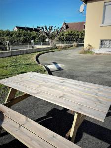 a wooden picnic table sitting in front of a street at Studio Le Plum'Art, 10mn Zoo de Beauval avec jardin in Noyers-sur-Cher