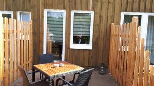 a table and chairs on a patio with a dog in a window at Ostwind in Hohenfelde +10 photos