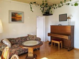 uma sala de estar com um sofá e um piano em Familienferienwohnung Villa Zaunkönigin em Bischofsheim an der Rhön