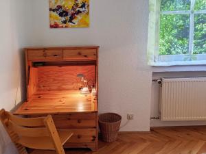 Habitación con cama de madera, escritorio y ventana. en Familienferienwohnung Villa Zaunkönigin en Bischofsheim an der Rhön