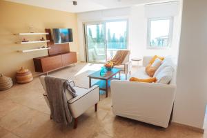 sala de estar con 2 sillas y sofá en Amathus suite with sea view en Limassol
