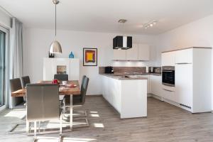 Una cocina y un comedor con mesa y sillas. en Appartement "Seeadler" - Oase am Haff, en Garz