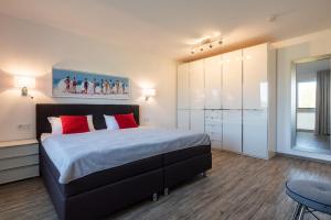 Un dormitorio con una cama grande con almohadas rojas. en Appartement "Seeadler" - Oase am Haff, en Garz 44 fotos más