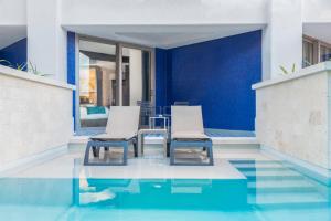 a patio with two chairs and a table in the water at Hard Rock Hotel Riviera Maya - Hacienda All Inclusive in Puerto Aventuras