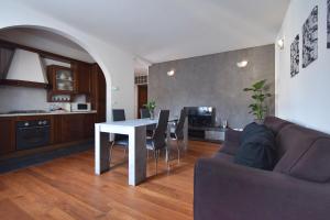eine Küche und ein Wohnzimmer mit einem Tisch und einem Sofa in der Unterkunft By the Hills Apartment in Montegrotto Terme