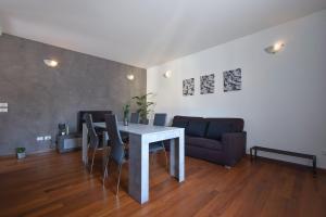 un soggiorno con tavolo e divano di By the Hills Apartment a Montegrotto Terme