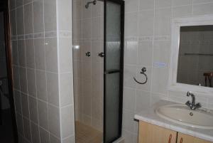 a bathroom with a shower and a sink at Remini in Jeffreys Bay