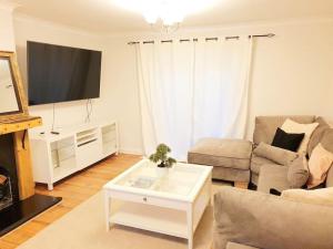 a living room with a couch and a coffee table at Specious 3bed property with parking & large garden in Aveley