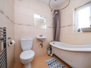 a bathroom with a toilet and a tub and a sink at Specious 3bed property with parking & large garden in Aveley