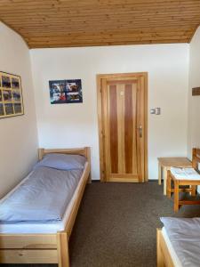 a bedroom with two beds and a wooden door at Relax Centrum Gól in Loučná nad Desnou